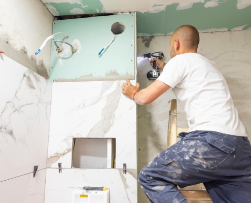 Construction worker installing wall in bathroom